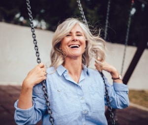 older woman on swing | Mohs Surgery